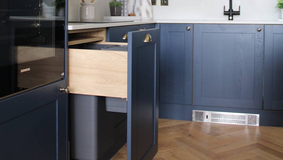 Blue kitchen featuring integrated bin