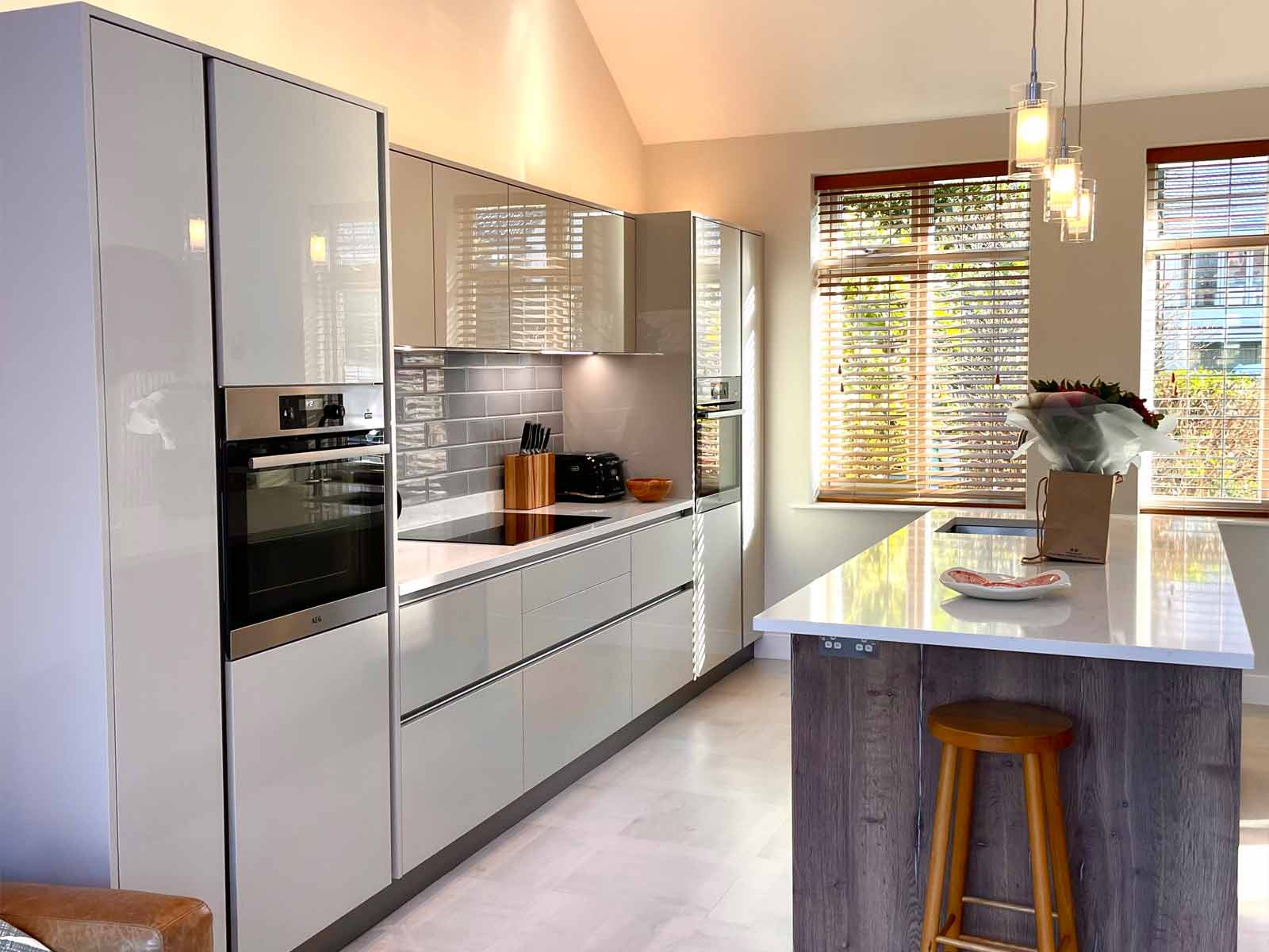 A handleless gloss cashmere kitchen with a tiled floor