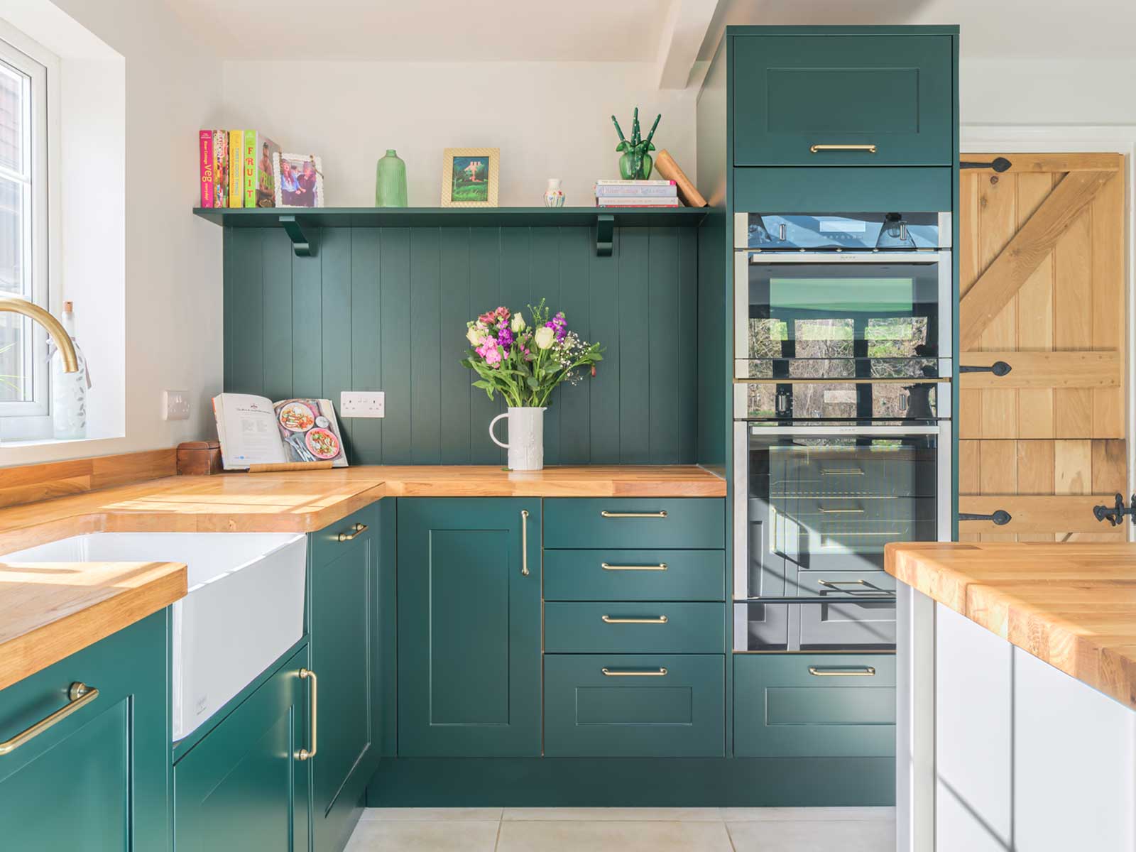 A kitschy kitchen with eclectic kitchen decor and green kitchen paint