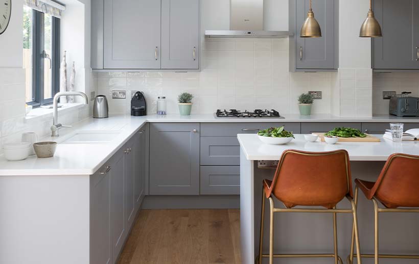A small kitchen island in a contemporary grey shaker kitchen