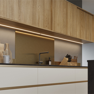 A handleless kitchen with strip lighting and gold metallic handlerails