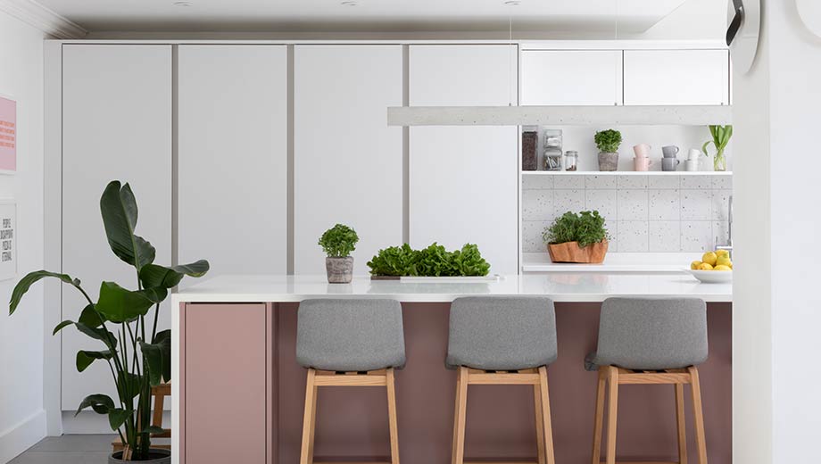 A modern grey kitchen with pink kitchen island