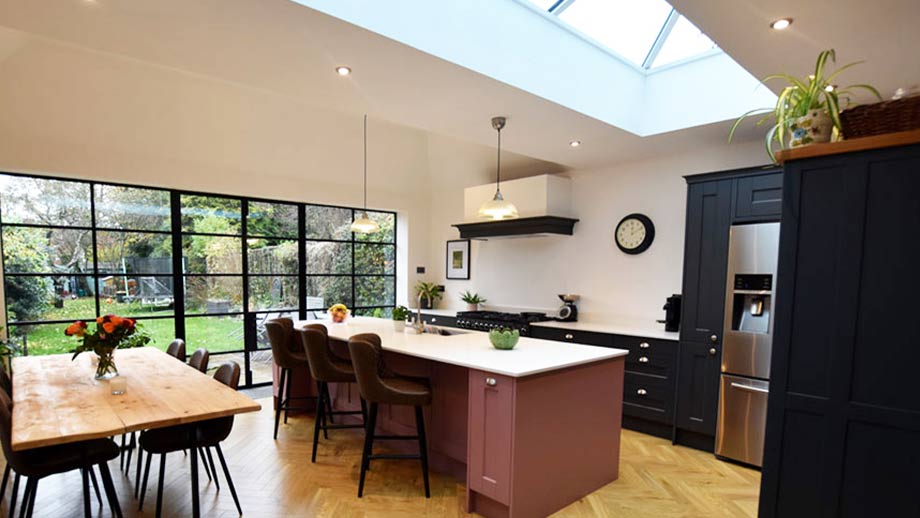 A kitchen extension with pink kitchen island