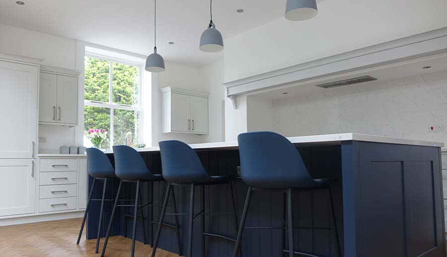 Blue kitchen island featuring grey kitchen units