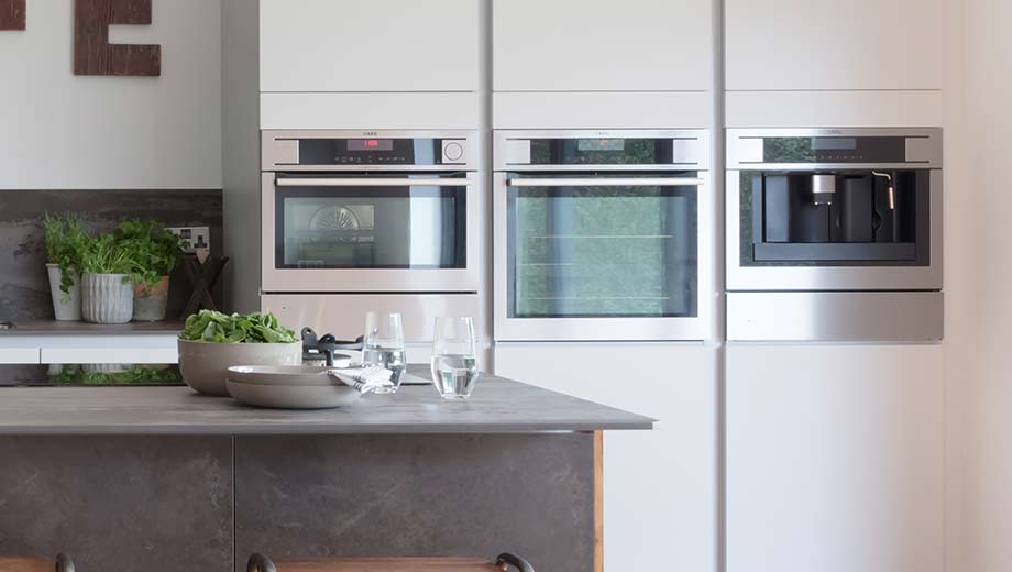 Modern handleless kitchen featuring built-in appliances