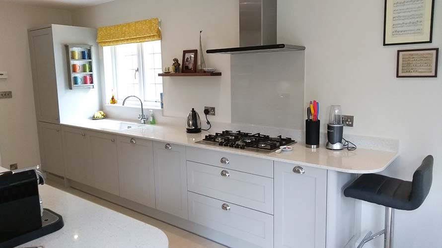 Shaker style galley kitchen in grey with a miniature breakfast bar