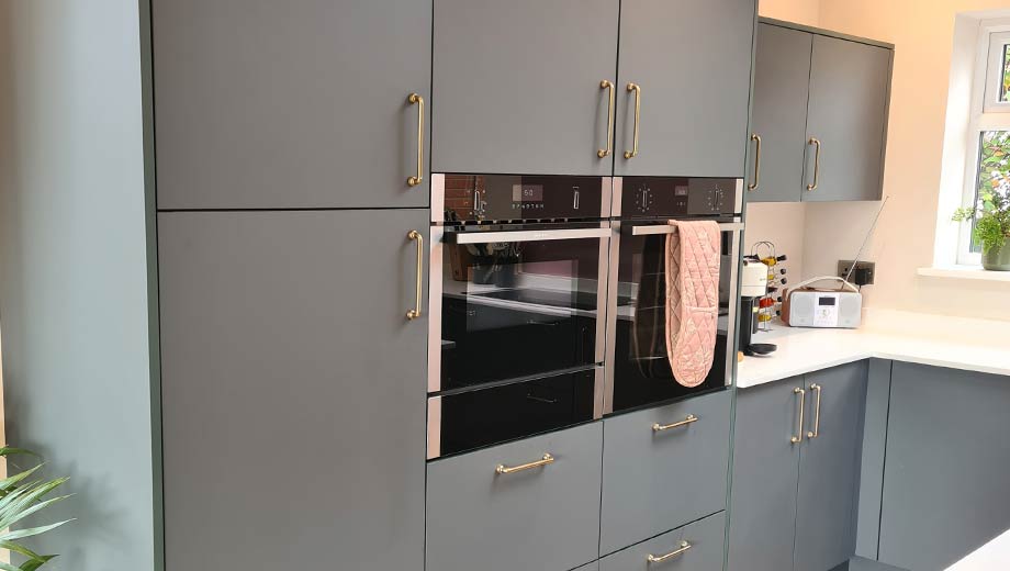 Gold handles in a green and pink kitchen