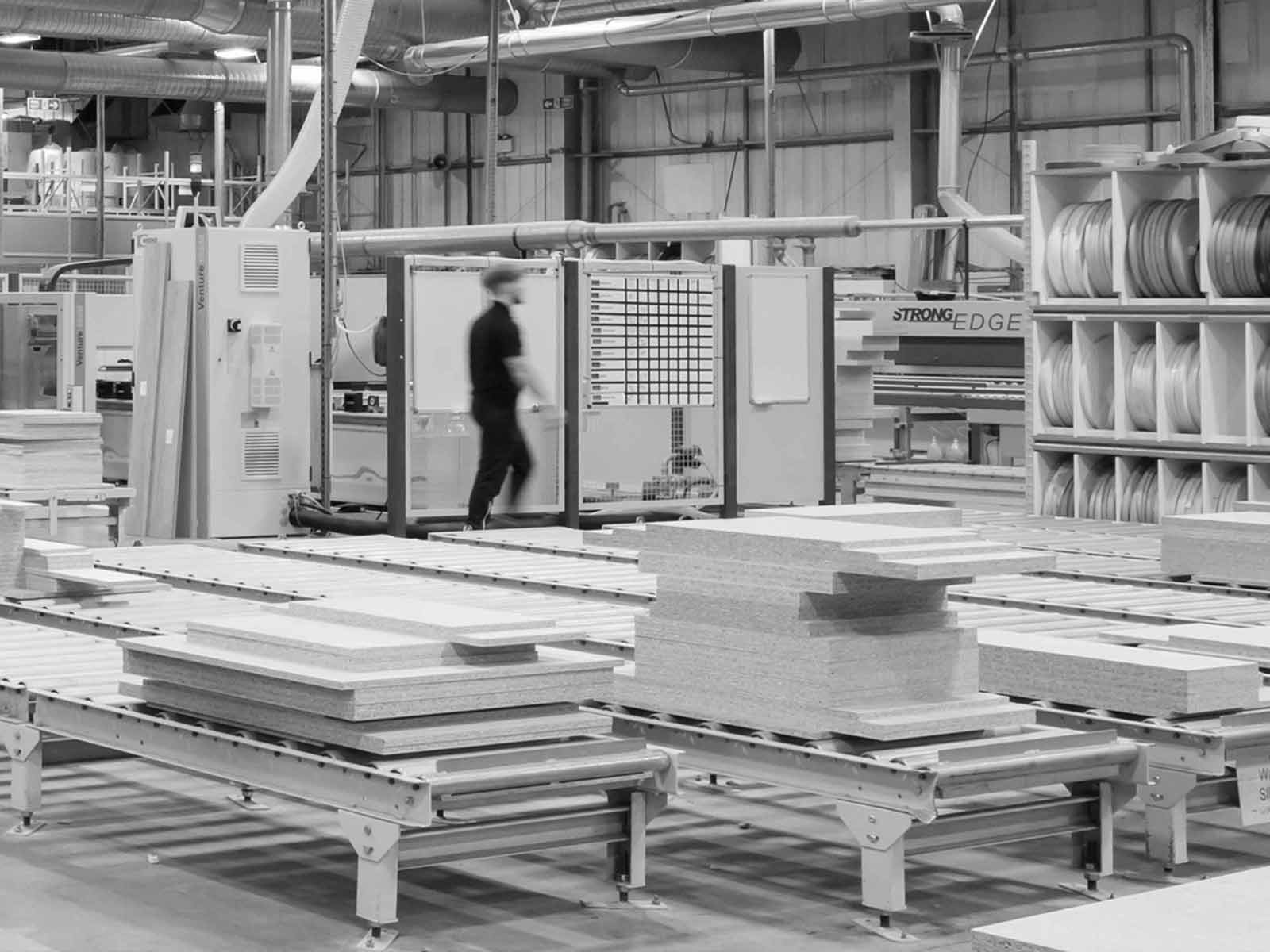 A kitchen manufacturing plant interior featuring rollers and shelf edging