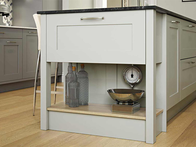 Biscuit green Chef’s table attached to kitchen island with dark marble worktop