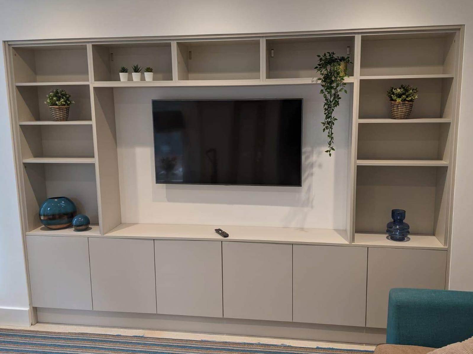Media wall with shelves used as a kitchen space-saving solution