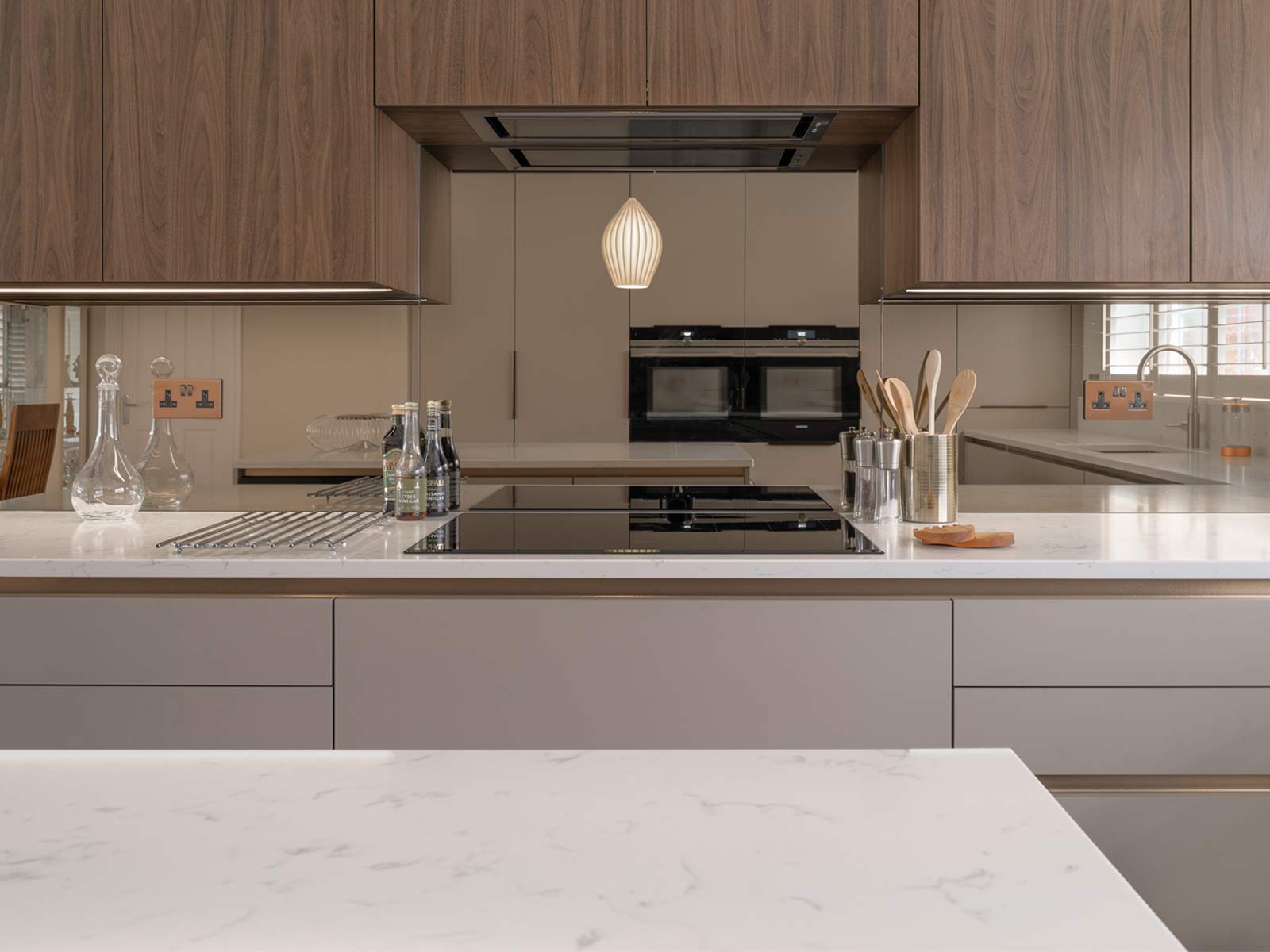 A cashmere kitchen with handleless grey cabinet doors and a kitchen island
