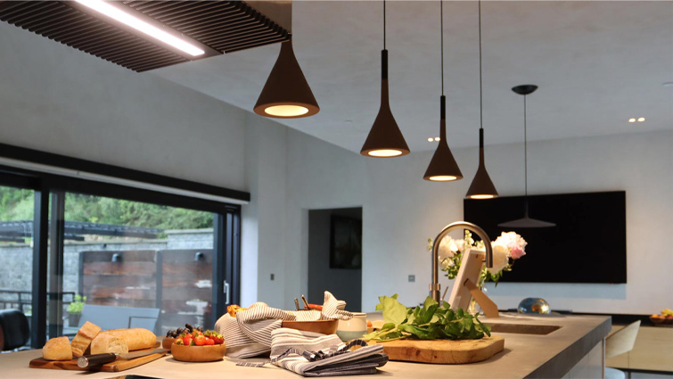 Pendant lighting above a desert modernist kitchen island