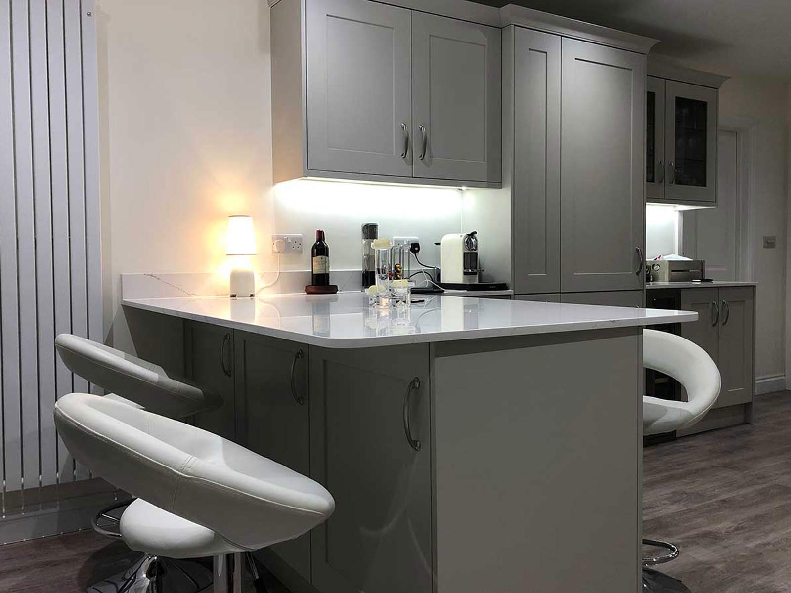 A kitchen peninsula worktop with mobile kitchen island barstools