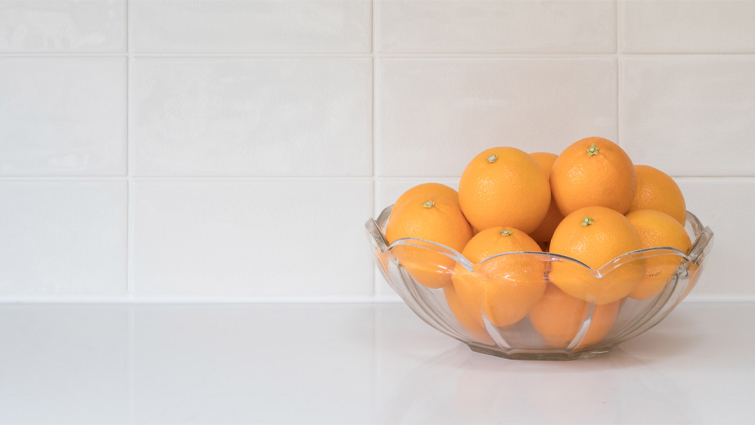 A bowl of oranges on a kitchen worktop ready for clove orange pomanders