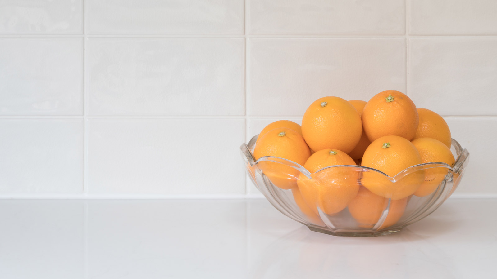 A bowl of oranges on a kitchen worktop ready for clove orange pomanders
