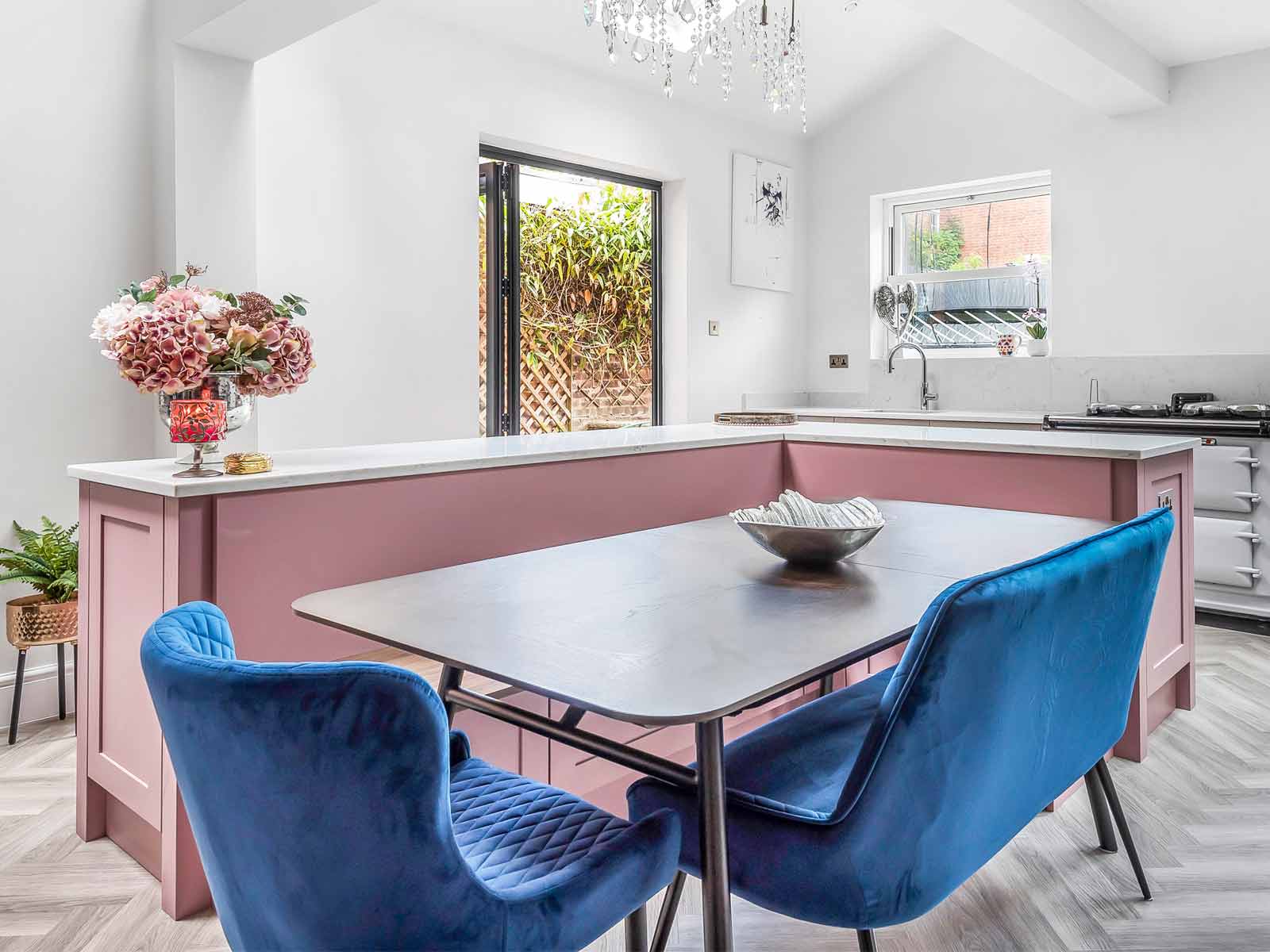 A pink kitchen range with Mexican kitsch flowers and blue seating