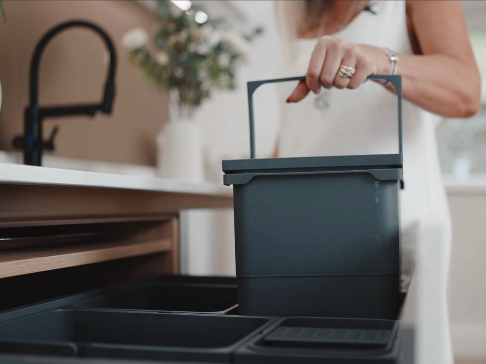 A kitchen compost bin inside a kitchen bin double unit