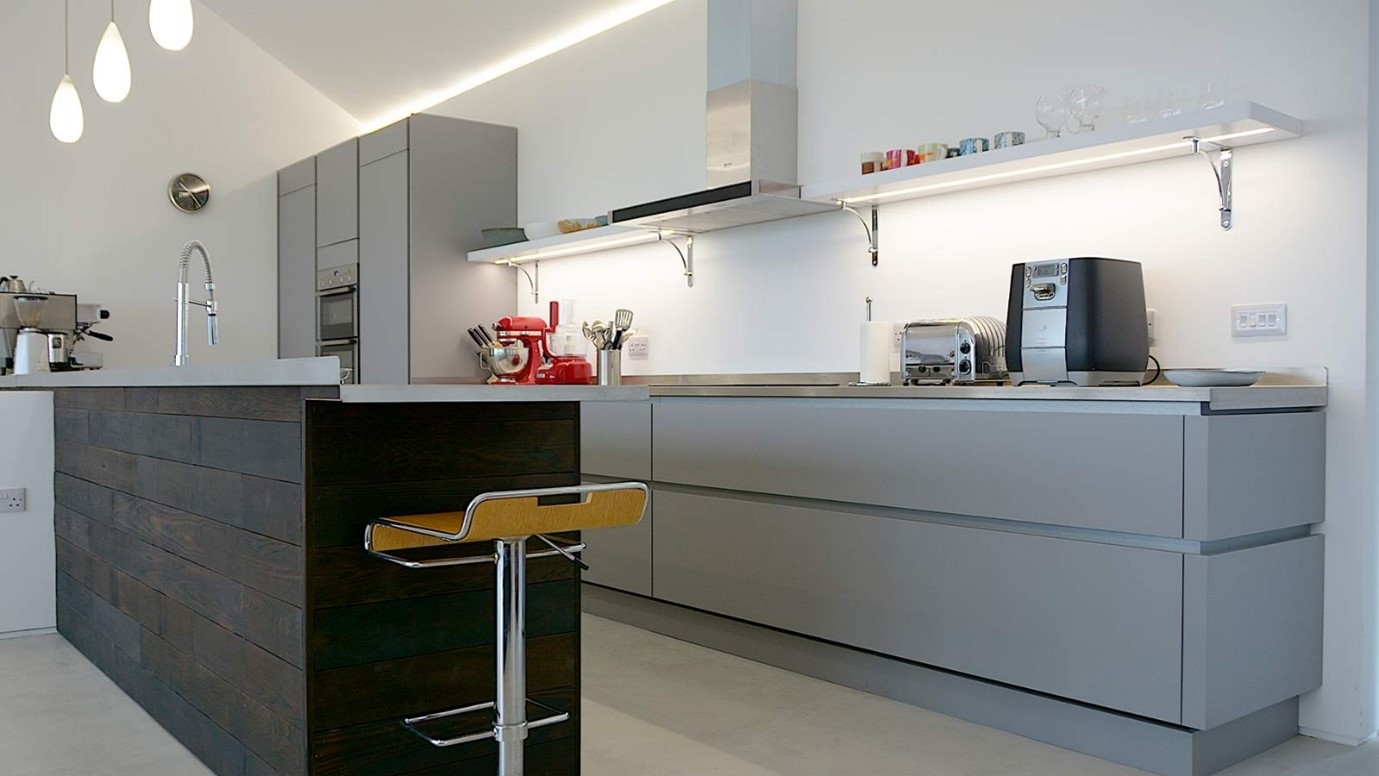 Small grey handleless galley kitchen with wood-effect breakfast bar