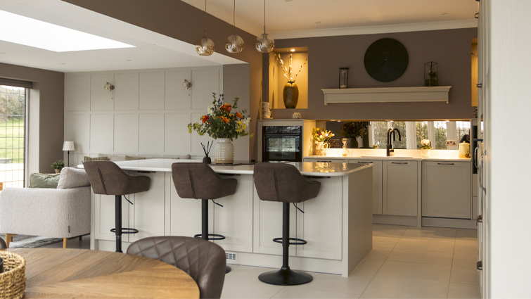 A greige kitchen with an open-plan layout and mushroom walls