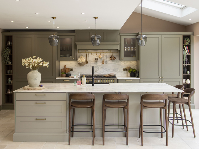A natural earthy kitchen with dark wood furniture and green cabients