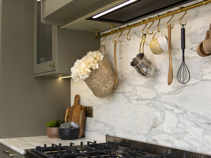 A natural earthy kitchen corner with hanging utensils and blended textures
