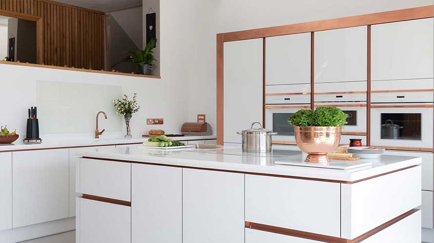A gloss scandi kitchen with rose gold handlerails