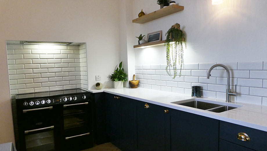 Small kitchen design with dark doors, cup handles and open shelving