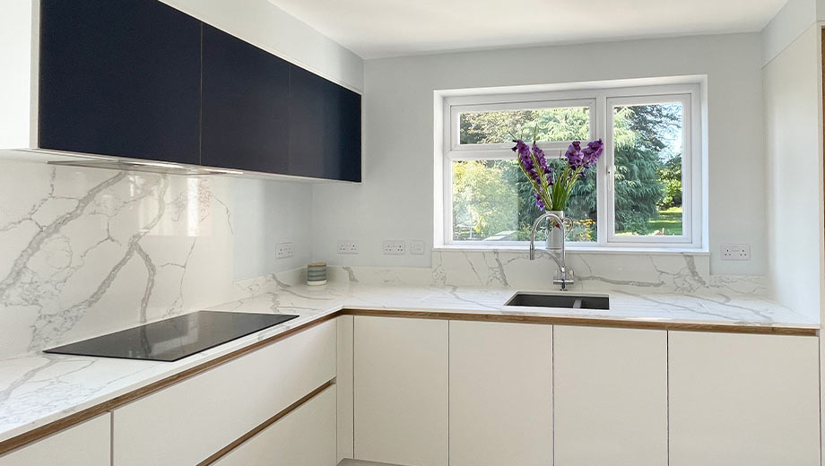 Small modern kitchen design with handleless cabinets and a marble worktop