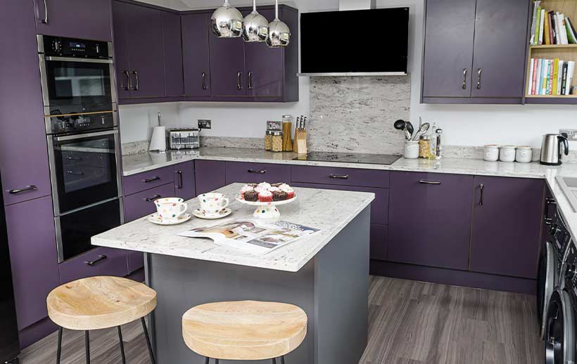 A small kitchen island in a modern purple kitchen